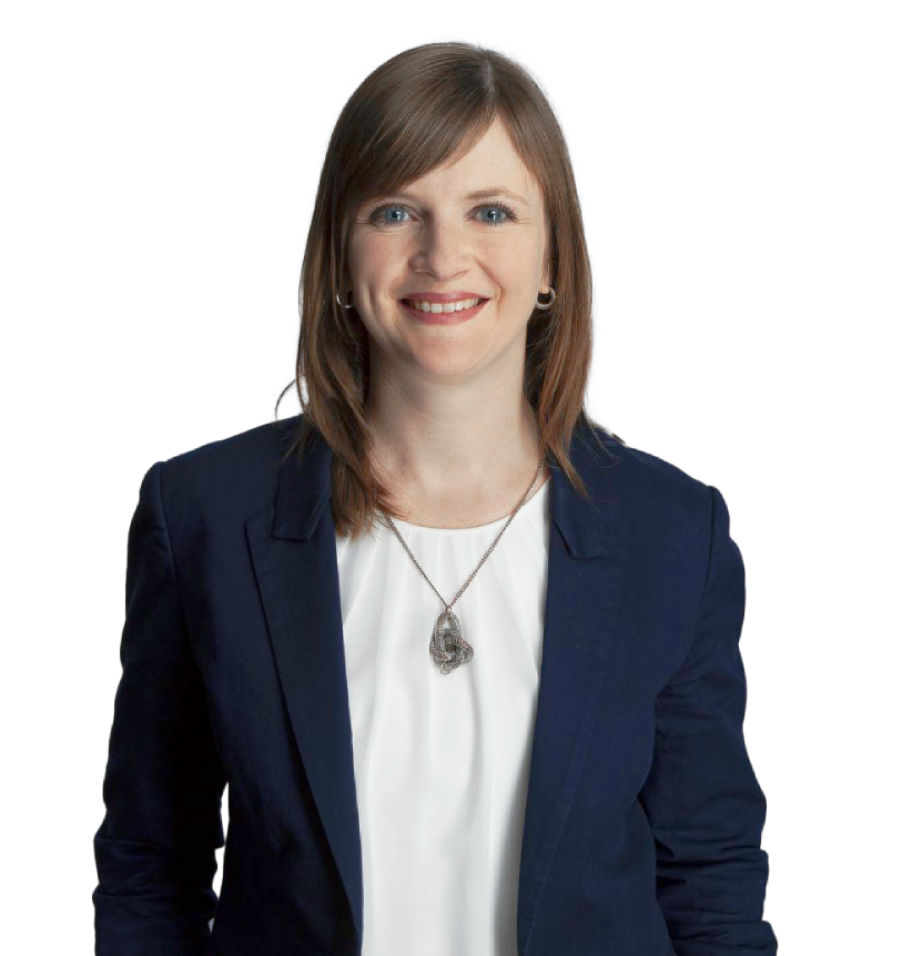 Eine lächelnde Annika Popp mit langen, braunen Haaren trägt einen blauen Blazer und eine weiße Bluse, während sie direkt in die Kamera schaut.